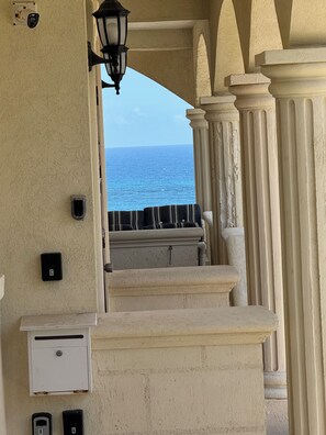 A view from a balcony with a stone balustrade, a light fixture, and a mailbox. - Luxury cliff apartment with pool and sea views. (Ocean City)