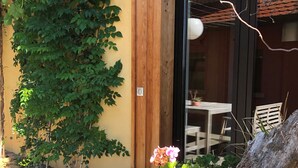 A wooden deck with a planter box containing flowers and a tree stump.