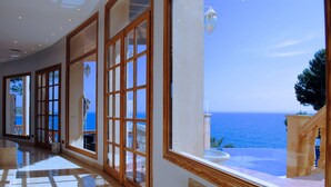 A spacious hallway with large windows offering a view of the sea.