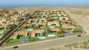Zona residencial con casas alineadas, con pequeños jardines delanteros y una calle en primer plano.
