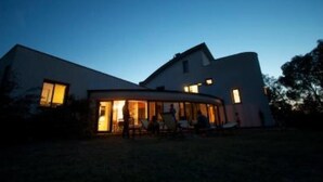 A modern house with a glass extension, a covered outdoor area, and a well-lit interior. - Large modern villa surrounded by olive trees, , 20 minutes to Rome          (Sacrofano)