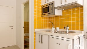 A kitchen with a microwave, sink, and coffee maker. - Studio in Macarena (Sevilla)
