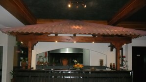 A kitchen with a wooden counter, a tiled backsplash, and a hanging light fixture. - Villa B Apartments (Ponta do Sol)