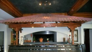 A kitchen with a built-in stove, a wooden counter, and a decorative ceiling. - Villa B Apartments (Ponta do Sol)