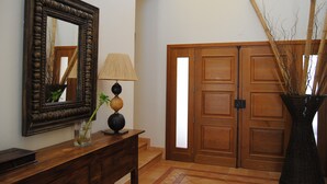 A wooden door with a mirror and a lamp on a wooden console table. - Luxury 4 bedroom Villa with private pool and garden (Sta. Eulalia)
