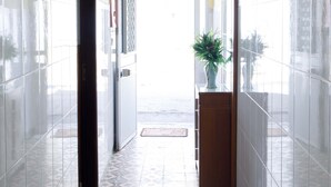 A hallway with tiled walls and floor, a hanging light fixture, and a potted plant. - House / Villa - Fuseta (Fuseta)