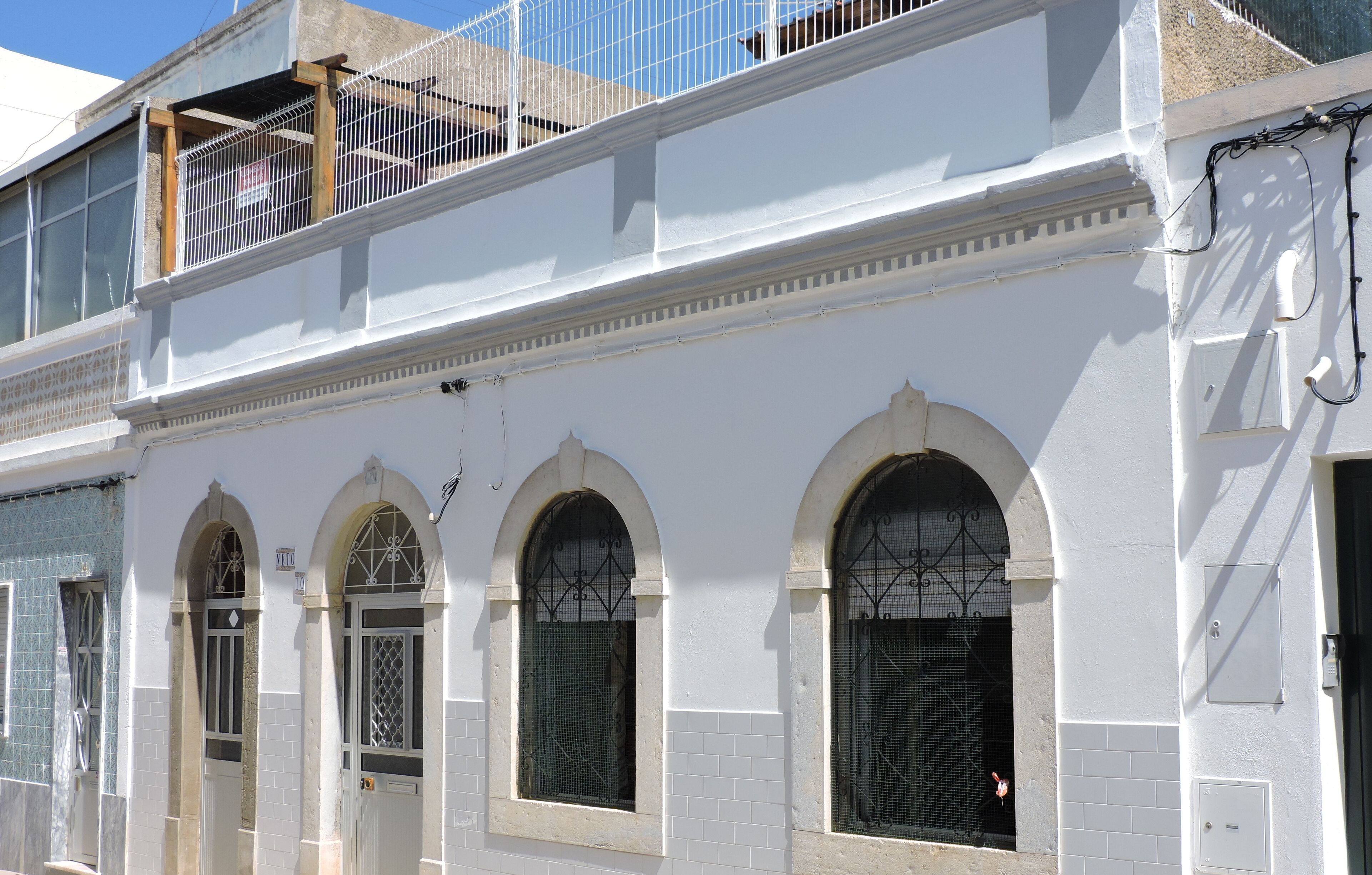A white building with arched windows and a balcony.