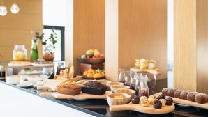 Un buffet proposant une variété de produits de boulangerie et de fruits.