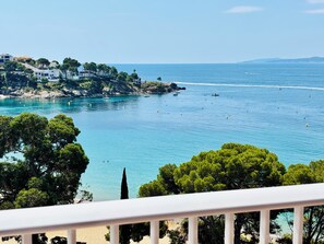 A coastal view with clear blue waters, a rocky shoreline, and buildings on a hillside. - Private building, quiet location, large apartment with large terrace, sea view, located in (Roses)