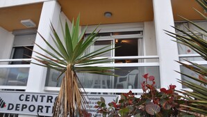 Un edificio con un cartel que dice "CENTRO DEPORTIVO" y una ventana con persianas visibles.