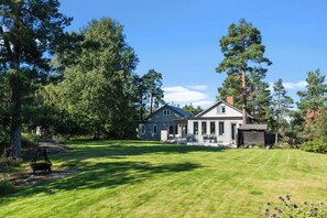 A two-story house with a large lawn and trees. - Modern house 15 min from Center of Stockholm (Boo)