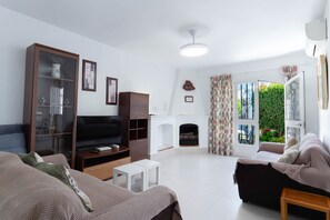 A living room with a television, sofa, and fireplace. - Los Pinos 25 Villas by Casasol (Nerja)