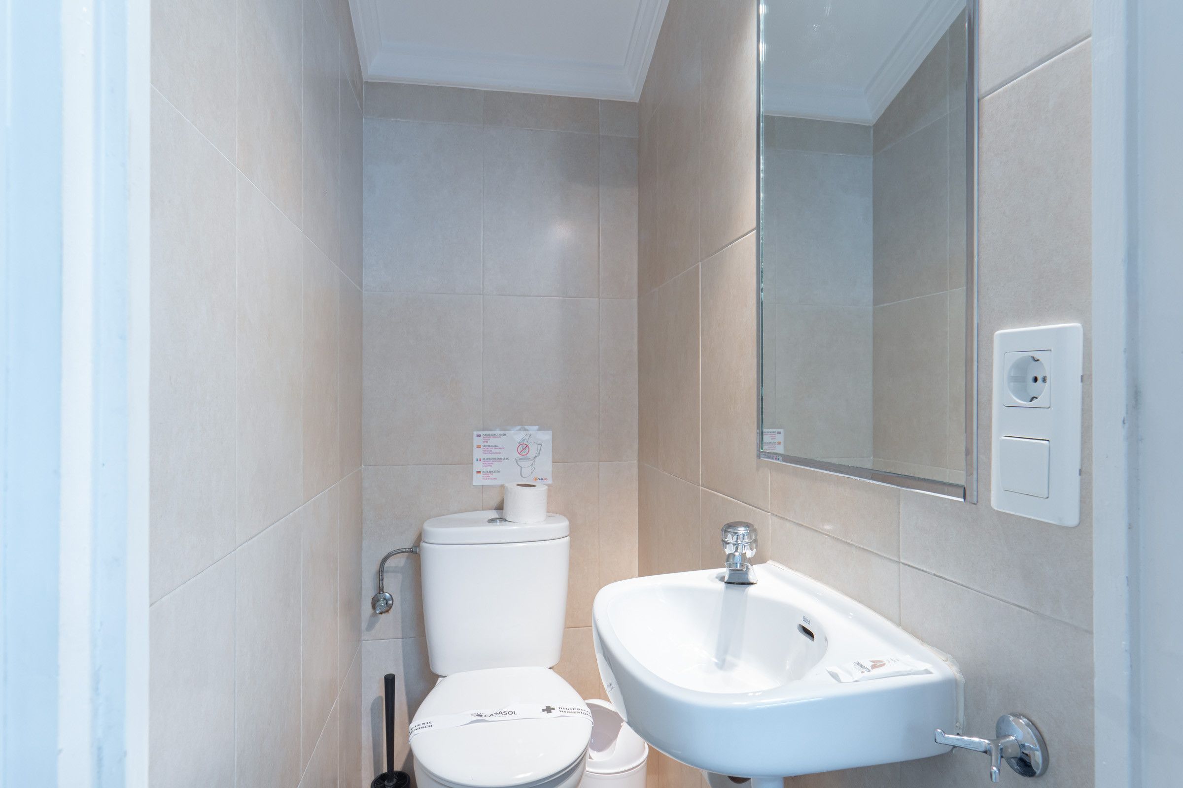 Une salle de bain avec des toilettes, un lavabo et un miroir.