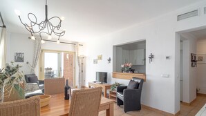 A modern living room with a dining table, chairs, a TV, and a fireplace. - Tamango Hill Alcazaba B by Casasol (Torrox)