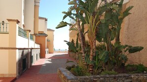 A pathway leading to a building with a stone wall and tropical plants. - Tamango Hill Alcazaba B by Casasol (Torrox)