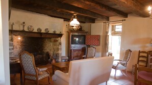 A cozy living room with a fireplace, wooden furniture, and a television.