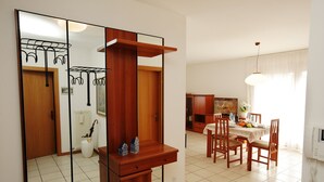 A dining area with a wooden table, chairs, and a hanging light fixture.