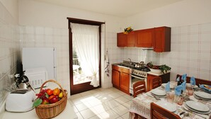A compact kitchen with a toaster, a sink, and a dining table set for four.