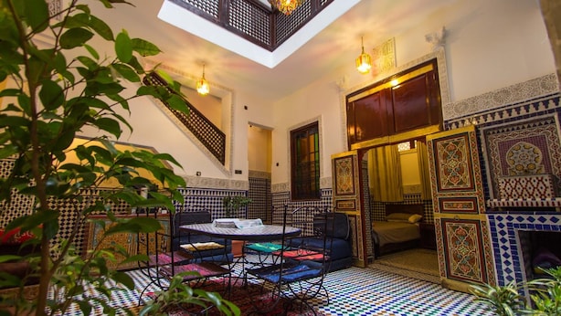 A Moroccan-style interior with a checkered floor, a central seating area, and a staircase leading to an upper level. - Dar el Mathaf (Fes)