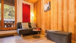 Ein gemütliches Zimmer mit einer Couch, einem kleinen runden Tisch und einer Bank.