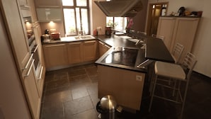 A modern kitchen with a central island, stainless steel appliances, and a window providing natural light.