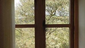 A wooden-framed window with a view of trees and a clear sky. - Secluded Detached Stable / Barn Conversion On The Border Of Shropshire And Wales (Oswestry Shropshire)