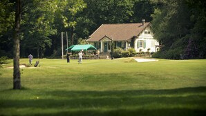Un terrain de golf avec un club-house en arrière-plan.