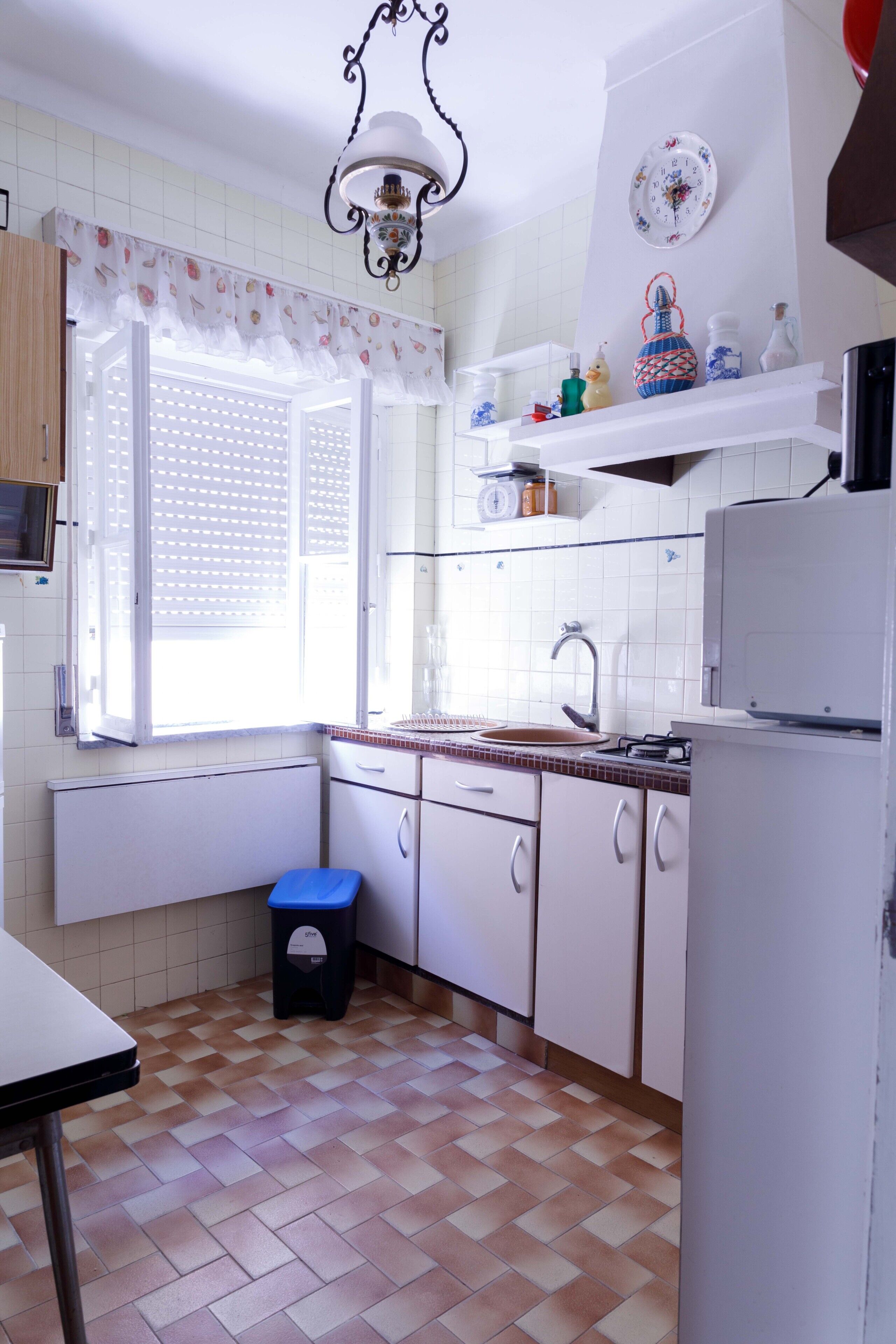 Uma cozinha compacta com janela, pia e geladeira.