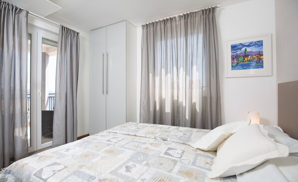 A bedroom with a bed, curtains, a wardrobe, and a framed picture on the wall. - 5 star Luxury villa,Amazing views, 50m from the beach ,heated pool,jacuzzi (seget vranjica)