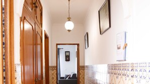 Un pasillo con piso estampado, armarios de madera y un banco.