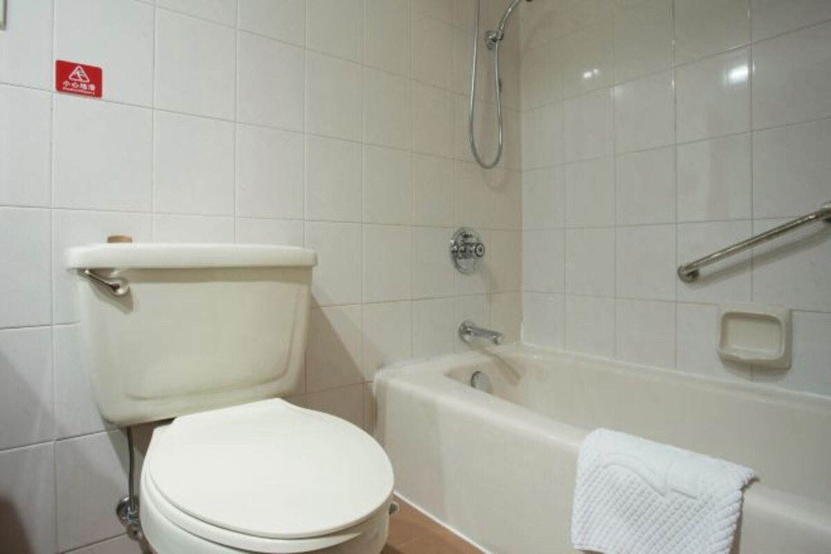 A bathroom with a toilet, a bathtub, and a shower.
