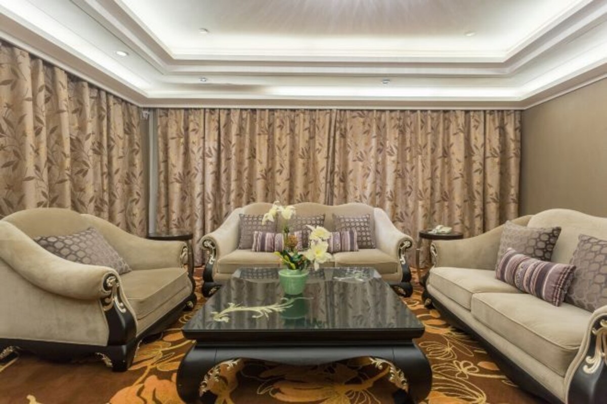 A living room with two sofas, a coffee table, and a patterned curtain.