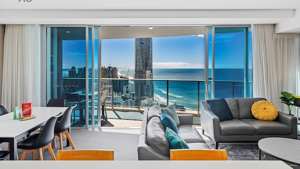 Uma sala de estar moderna com vista para a cidade, varanda e área de jantar.