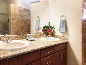 A bathroom with two sinks, a mirror, and wooden cabinets. - Casa Taylor Gran Pacifica Resort (Villa El Carmen)