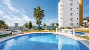 Une piscine avec un bâtiment blanc en arrière-plan.