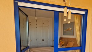 A bedroom with a bed, a wardrobe, and a window with curtains. - Your vacation home with fantastic south-facing terrace and breathtaking sea view (Manilva)