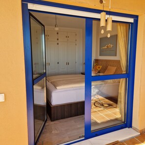 Ein Schlafzimmer mit Bett, Schrank und einem Vorhangfenster.