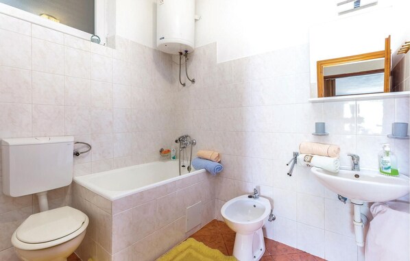 Ein Badezimmer mit Toilette, Badewanne, Bidet und Waschbecken.