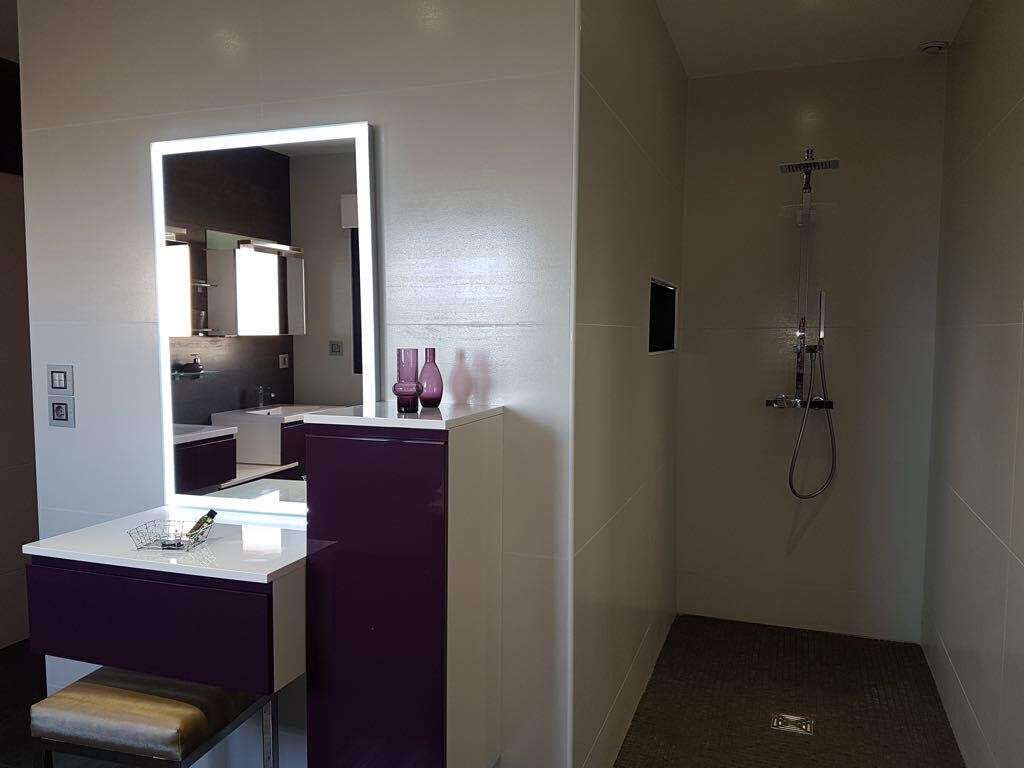 Une salle de bain moderne avec un meuble-lavabo, un miroir et une douche.