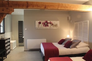 A bedroom with a bed, a nightstand, a dresser, and a painting on the wall.