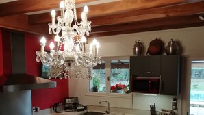 Une cuisine avec un plafond en bois, un lustre, un évier, une cuisinière et des placards.