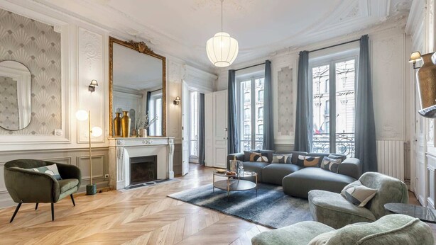 A spacious living room with a fireplace, a large mirror, and a modern sofa set. - Sweett | Saint Lazare (Paris)