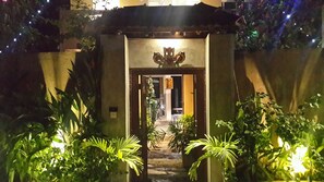 A gated entrance with a decorative archway, surrounded by lush greenery and a small water feature. - Cycling Hostel Sri Lanka (Unawatuna)