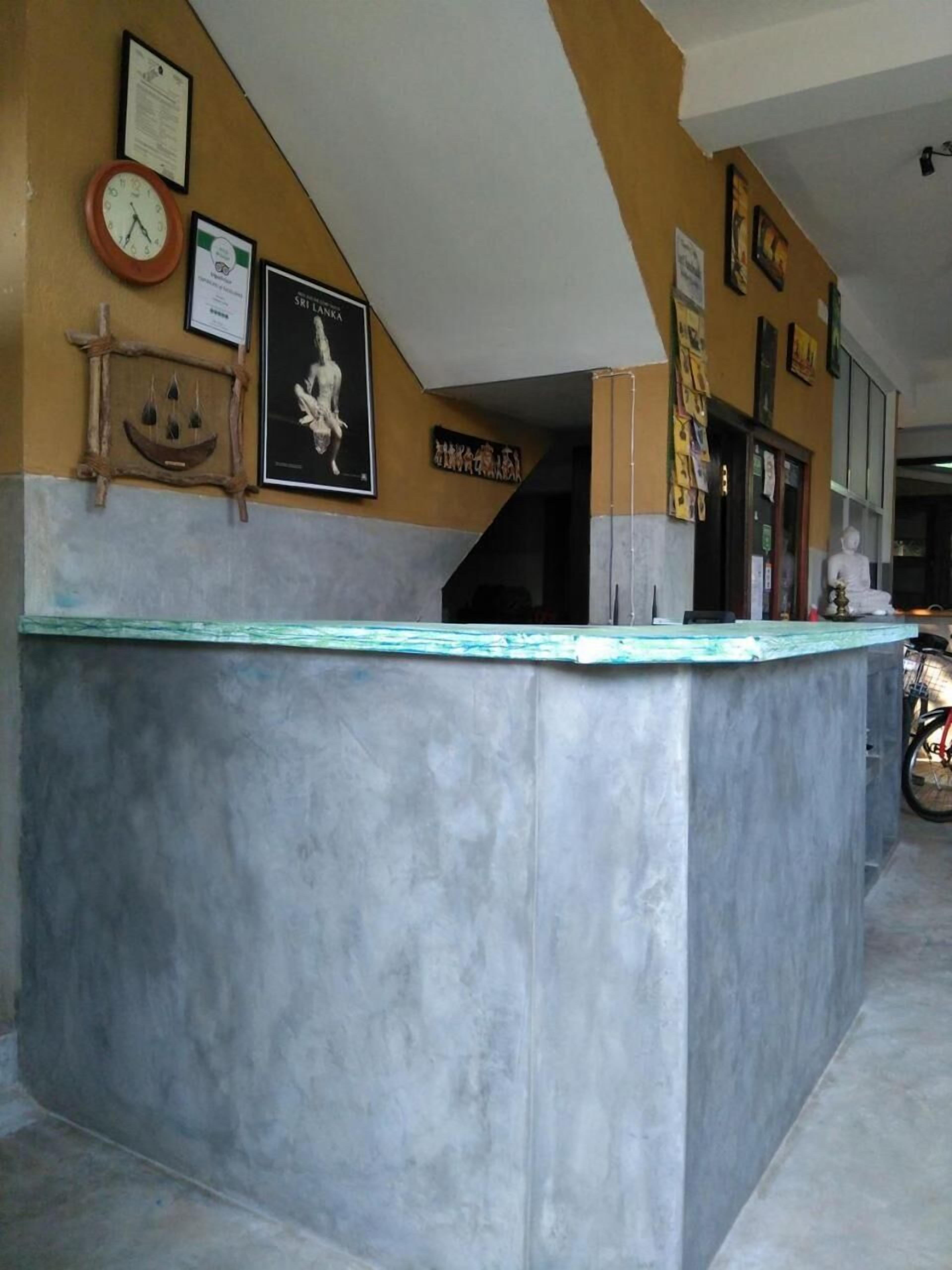 A reception area with a marble counter, framed certificates, a clock, and a Buddha statue.