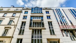 A multi-story building with a mix of architectural styles, featuring large windows and balconies.