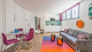 A modern apartment with a dining area, kitchen, and living space.