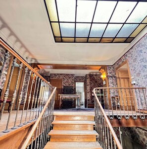 A staircase with ornate balusters leading to a landing with a chandelier. - GRANDE DEMEURE FAMILIALE confortable pour 22 personnes (Saint-Marcel-Lès-Annonay)