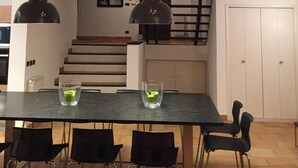 A dining area with a table and chairs, a staircase, and a ceiling light fixture. - Villa with a breathtaking view, in a quiet countryside,  <br>One week minimum rent  (Saint-Jeannet)