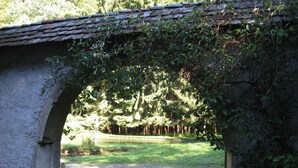 A stone bridge with an arch, surrounded by greenery and a gravel path. - A holiday in the Petite Pierre in the middle of the forest (Lohr)
