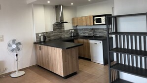 Een moderne keuken met een centraal eiland, een magnetron en een vaatwasser.